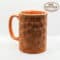 Handmade terracotta mug with geometric hexagon pattern for tea or coffee.