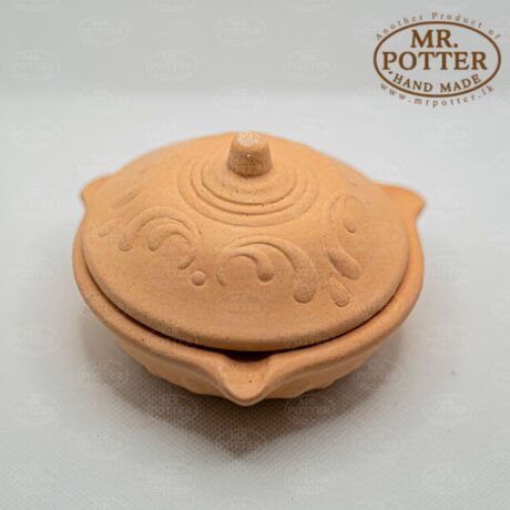 Handmade terracotta pot with intricate embossed design for home decor and plant display.