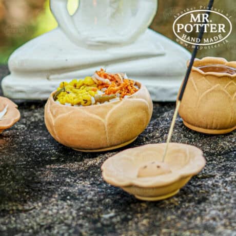 Colorful traditional Sri Lankan wooden bowls with local delicacies on dark stone surface.